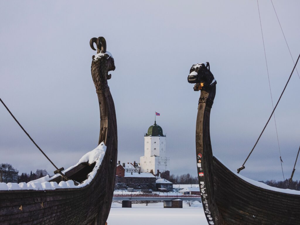 Viser kopier af vikingeskibe med et snedækket middelalderslot i baggrunden.