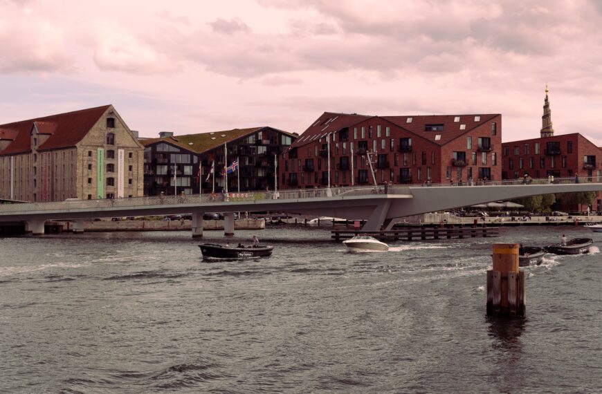 Scenic view of Inderhavnsbroen bridge and waterfront buildings in Copenhagen at dusk.
