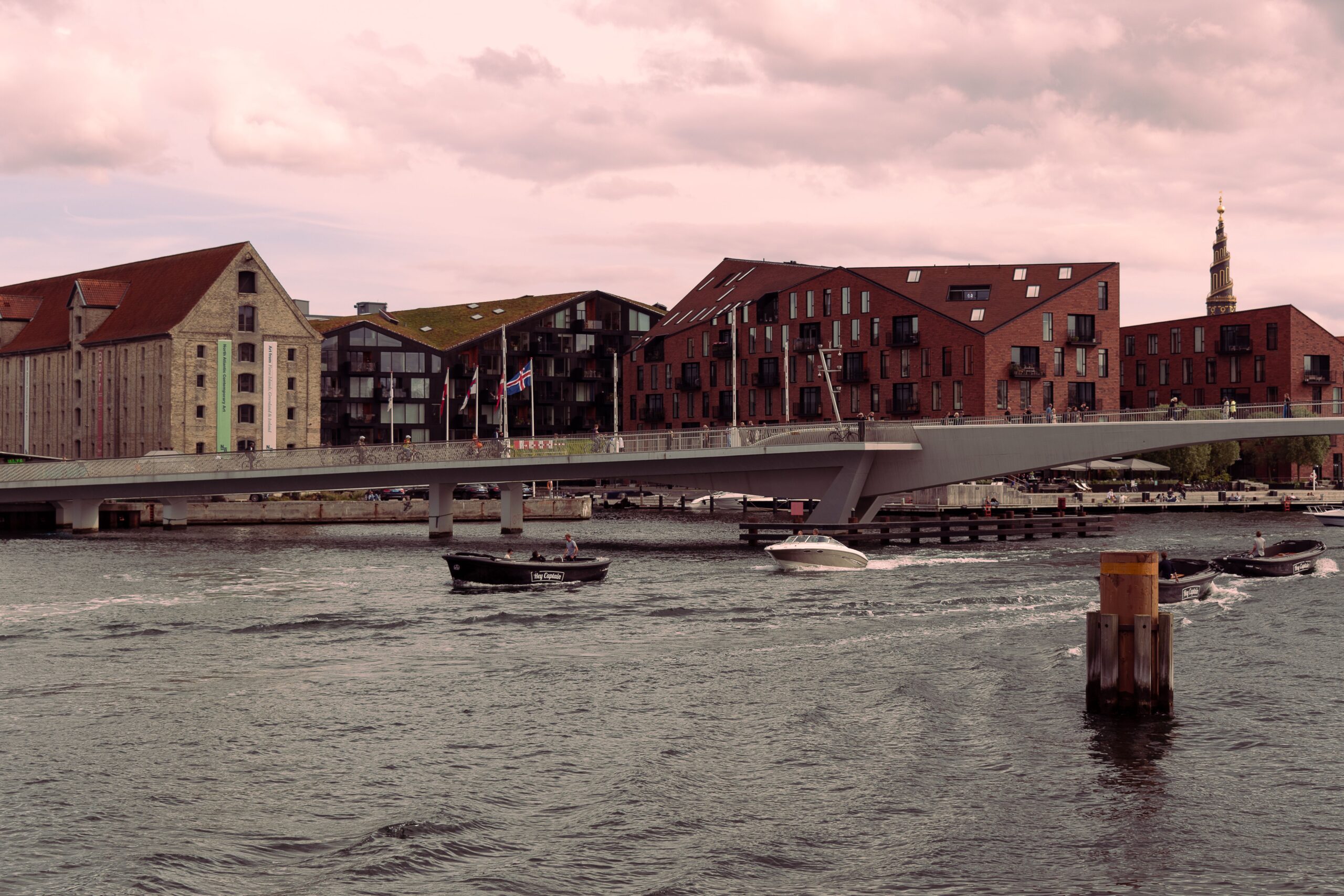 Scenic view of Inderhavnsbroen bridge and waterfront buildings in Copenhagen at dusk.