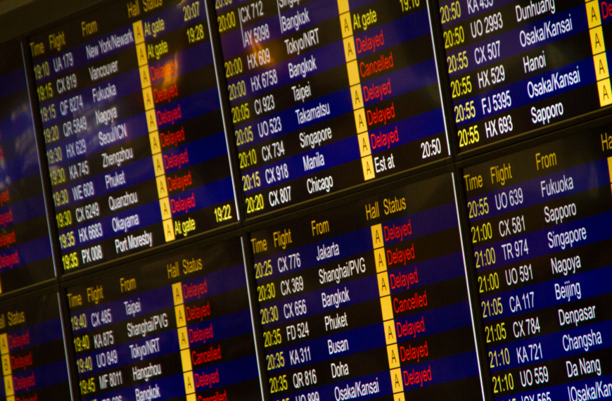Close-up of digital flight information board showing arrivals and departures at an airport.