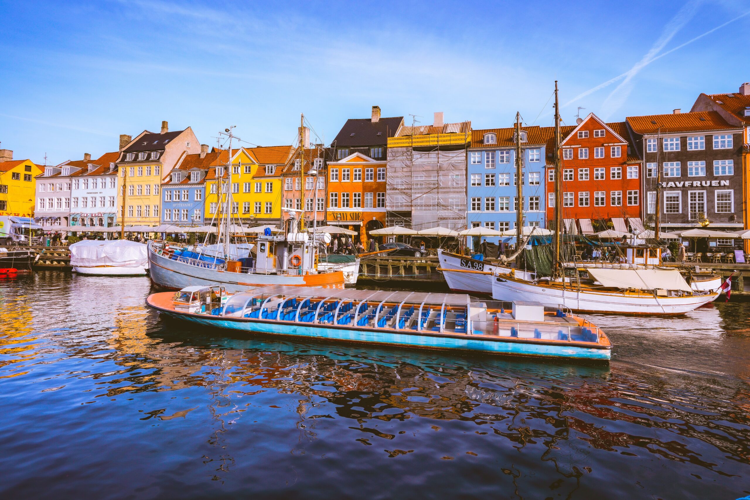 Vibrant Nyhavn canal in Copenhagen with colorful buildings and boats.