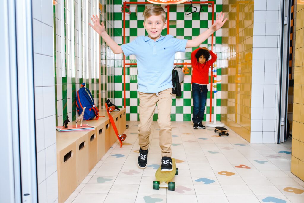 Børn leger på skateboard i et farverigt indendørs legeområde
