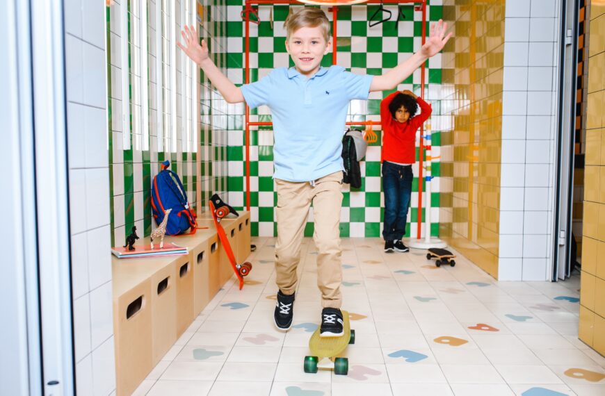 Two kids skateboarding inside a tiled room, enjoying fun activities.