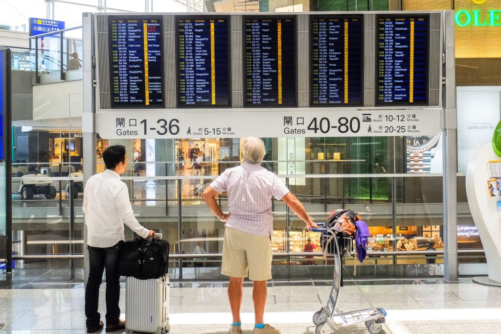 Passagerer gennemgår flyinformation på en digital skærm i terminalen i Hongkong Lufthavn.