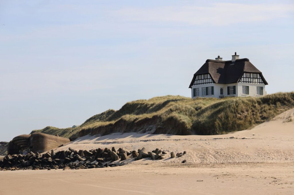 Naturskøn udsigt over et strandhus i klitterne i Løkken, Danmark, på en solrig dag.