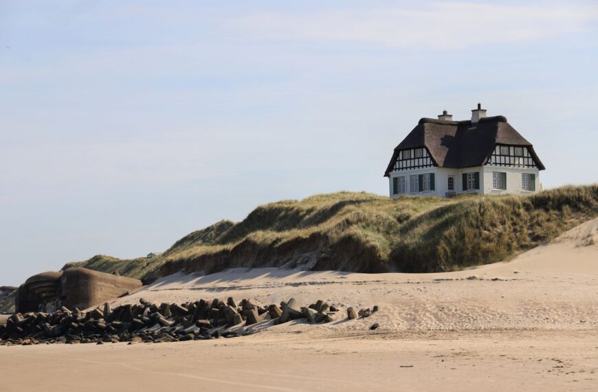 Scenic view of a beach house on dunes in Løkken, Denmark, on a sunny day.