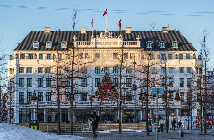 Iconic Hotel D'Angleterre adorned with holiday decor in wintery København setting.