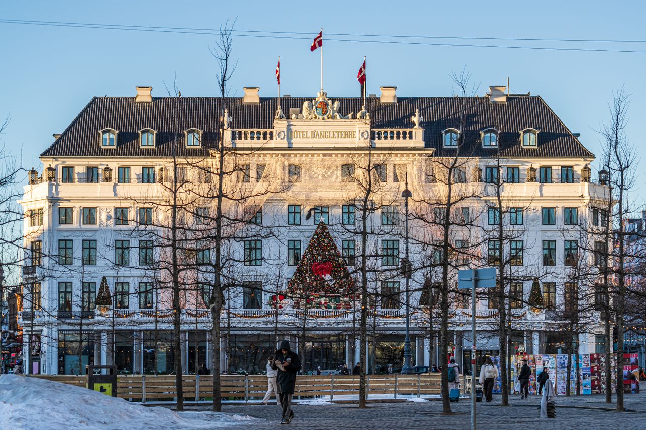Iconic Hotel D'Angleterre adorned with holiday decor in wintery København setting.