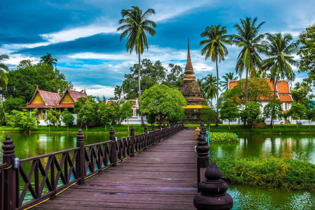 Oplev den rolige skønhed ved templet i Sukhothai omgivet af frodig natur og fredfyldt vand