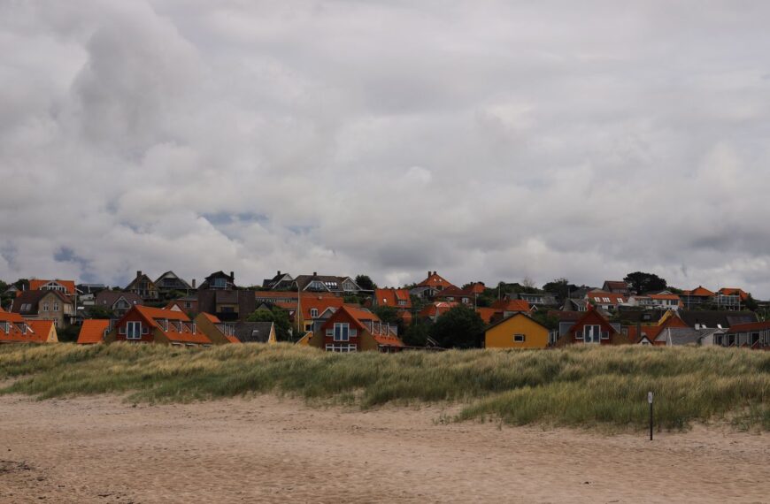 Picturesque view of colorful houses along the sandy beach in Hundested, Denmark.