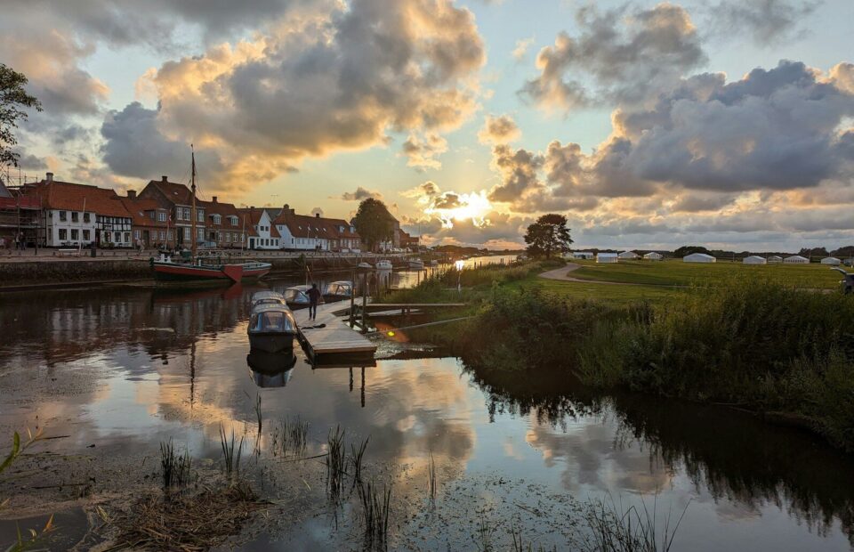 Både og huse ved Ribe Å under en skyet aftenhimmel