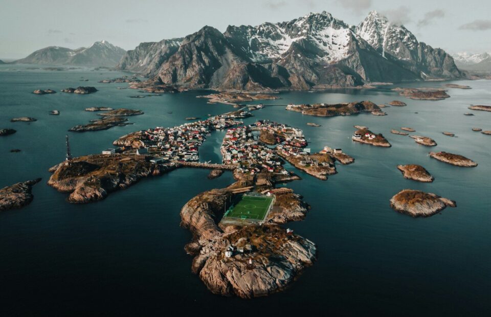 Henningsvær i Lofoten set fra luften med små øer, havn og bjerge