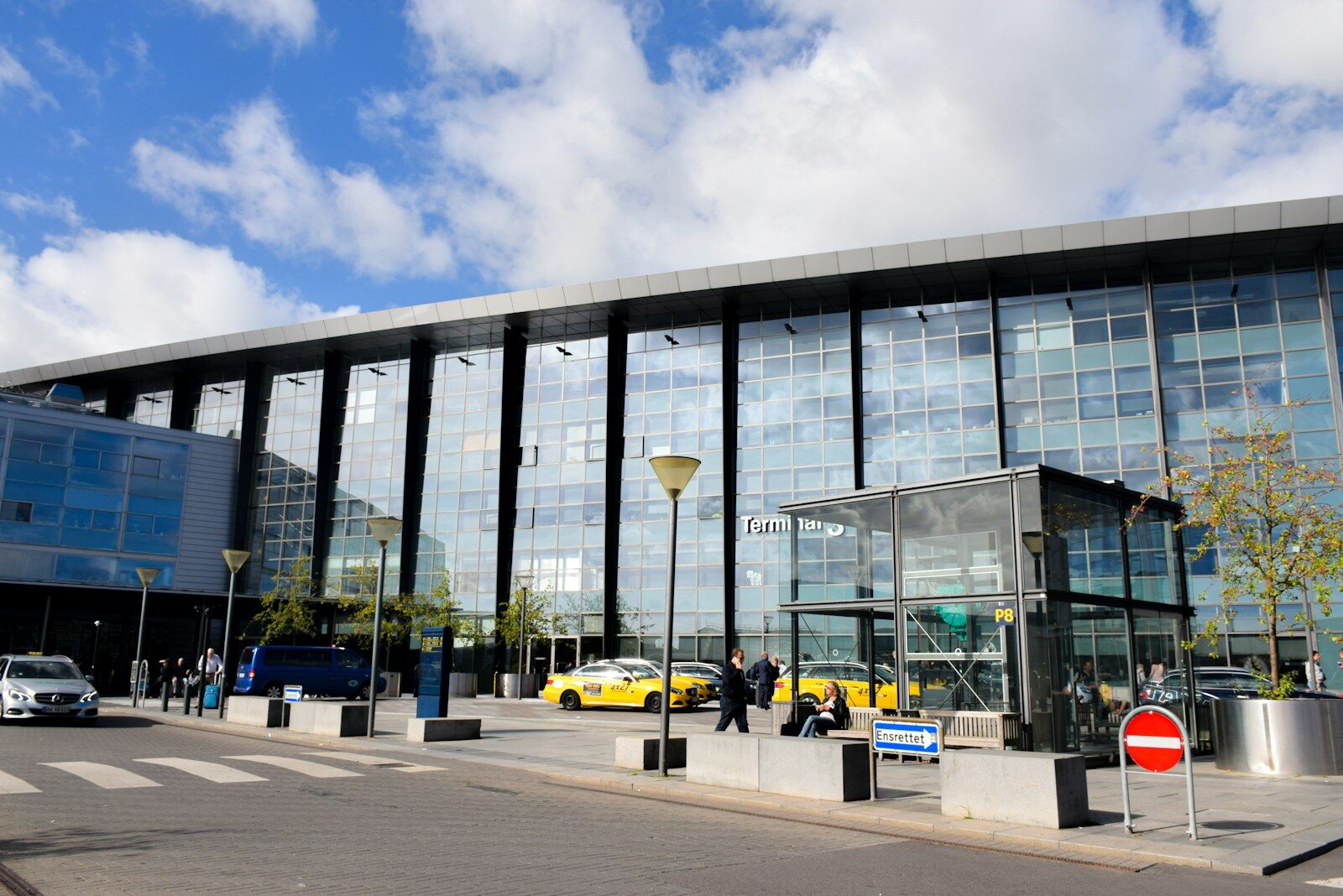 Terminalbygning med glasfacade og taxier ved Københavns Lufthavn