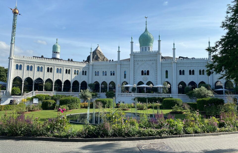 Nimbs hvide facade med grønne kupler set fra haven i Tivoli